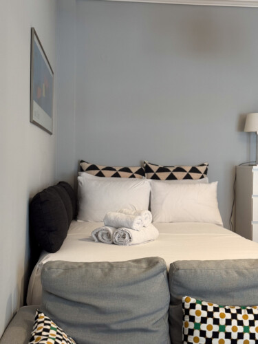 Modern one-bedroom apartment in the center of Thessaloniki with stylish living space, comfortable bed, and capacity for up to four guests.