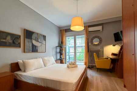 Modern one-bedroom apartment in the center of Thessaloniki with stylish living space, comfortable bed, and capacity for up to four guests.