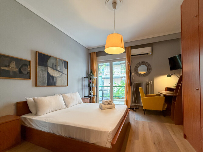 Modern one-bedroom apartment in the center of Thessaloniki with stylish living space, comfortable bed, and capacity for up to four guests.