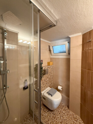 Modern one-bedroom apartment in the center of Thessaloniki with stylish living space, comfortable bed, and capacity for up to four guests.