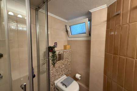 Modern one-bedroom apartment in the center of Thessaloniki with stylish living space, comfortable bed, and capacity for up to four guests.