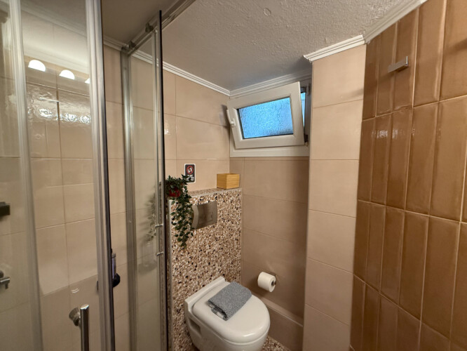 Modern one-bedroom apartment in the center of Thessaloniki with stylish living space, comfortable bed, and capacity for up to four guests.