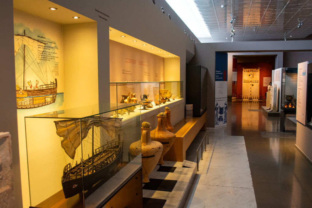 Exhibition hall at the Archaeological Museum of Thessaloniki with ancient amphorae, trade artifacts, and ship model