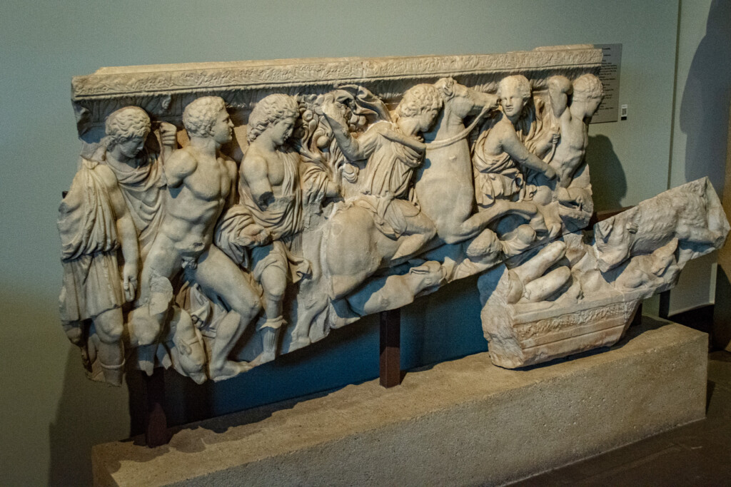 Marble relief depicting battle scene with horsemen and warriors at the Archaeological Museum of Thessaloniki