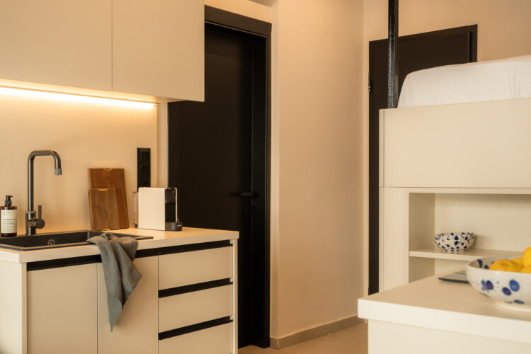 Compact and modern kitchen with coffee machine and wood finishes at FOS Apartments