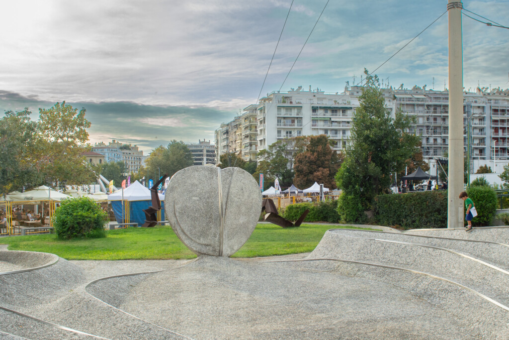 Outdoor sculpture and public art installation near MOMus Museum of Contemporary Art in Thessaloniki with city buildings and park in the background