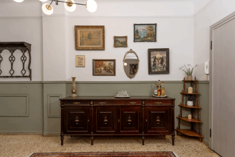 halu! Vintage living room interior with a wooden sideboard. Framed art and mirror on the wall. Warm lighting and cozy ambiance showcasing antique charm.