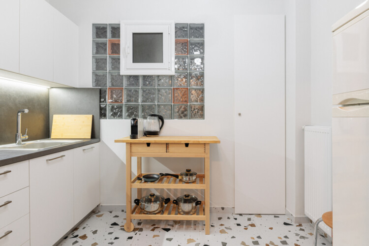 Modern fully equipped kitchen with stove, oven, sink, and storage space. Includes essentials like a kettle and coffee maker, making it ideal for preparing meals and enjoying a comfortable stay.