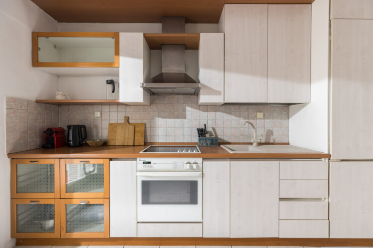 Halu! Modern kitchen with white cabinets, stainless steel appliances, and wooden countertops. Features include a built-in oven, electric stove, and sleek design elements.