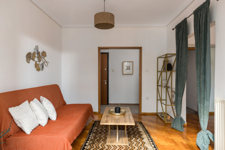 halu! Cozy living room with orange sofa and white pillows a wooden coffee table a stylish rug and elegant wall art creating a warm and inviting atmosphere