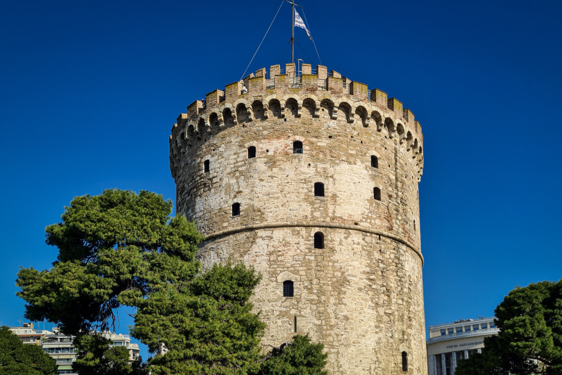 Halu! Discover the iconic White Tower of Thessaloniki under a clear blue sky. This historic landmark is a symbol of the rich cultural heritage in Greece.