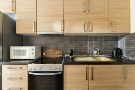 halu! Modern kitchen design in Indiana by halu! featuring wooden cabinets, a microwave, a sleek oven, and a cozy countertop for an inviting cooking space.