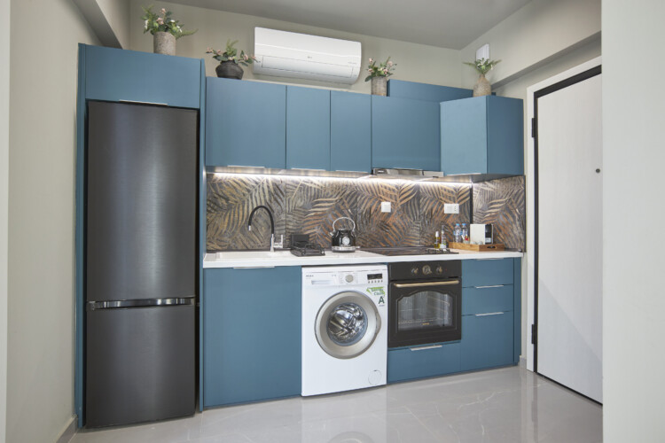 Halu! Modern kitchen in Verde premium apartments featuring stylish blue cabinets elegant countertops and top appliances offering luxury living in a contemporary design.