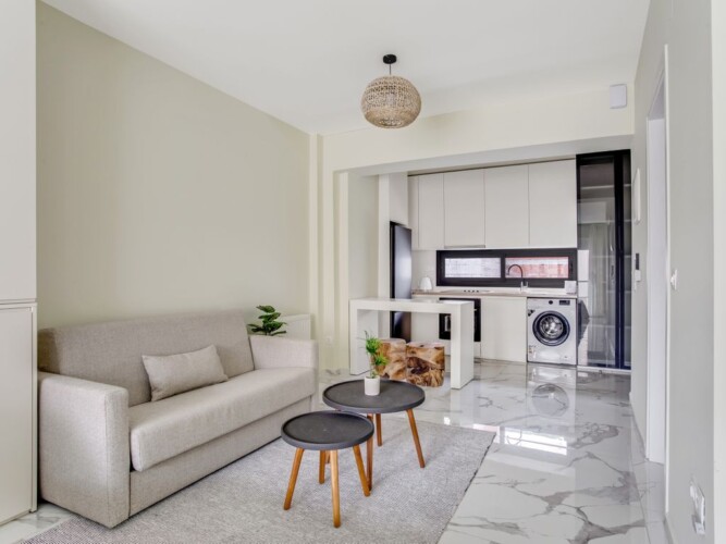 Halu! Discover the elegant interior of Verde Premium Apartments featuring a modern living area with a cozy sofa and stylish kitchen. Ideal for luxurious urban living.