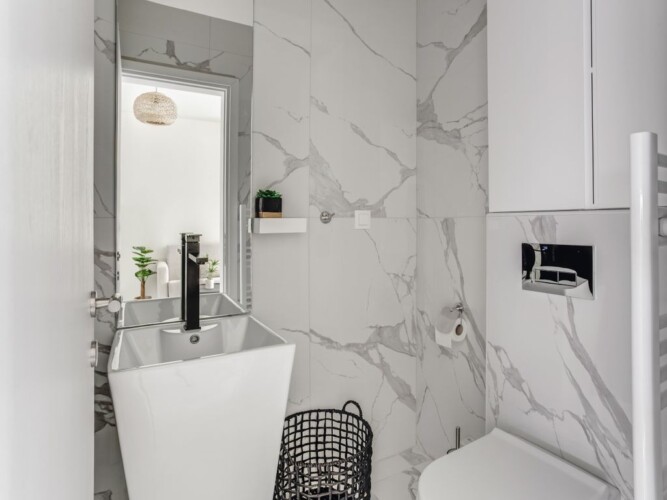 Halu! Experience luxury living with Verde premium apartments featuring a modern bathroom design with elegant fixtures and stylish marble walls. Perfect urban sanctuary.