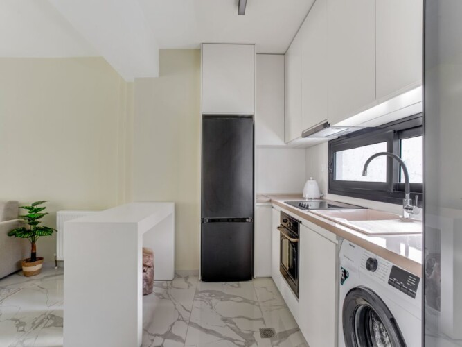 Halu! Experience modern living at Verde Premium Apartments with a sleek kitchen featuring high-end appliances ample natural light and elegant marble flooring.