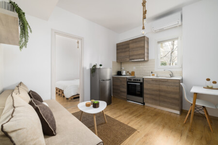 halu! Explore the modern interior of Ourania Lofts and Suites in Thessaloniki featuring a cozy living area and fully equipped kitchen offering comfort and style.