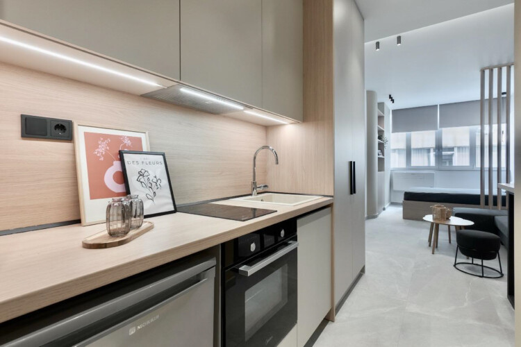 halu! Discover the modern kitchen design in Odyssey - Premium SKG suites located in Ladadika Center featuring sleek appliances and a cozy dining area for guests.