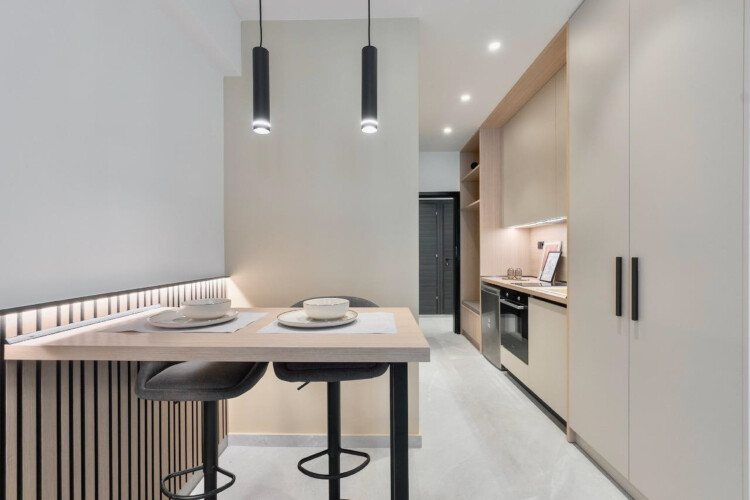 Halu! Discover the modern kitchen design at Odyssey - Premium SKG suites in Ladadika Center featuring sleek furnishings and ambient lighting for a luxurious stay.
